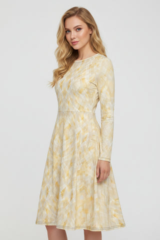 A long-sleeve A-line dress with a pleated skirt, featuring a yellow and white geometric diamond pattern, shown against a plain white background.